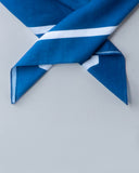 Blue fabric with white stripes on a light gray background - blue bandanna / headscarf  with text "tie your style baby" Sleeves Studios' branding