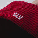 Red corduroy cap with soft ribbed texture, curved “Sleeves Studios” front embroidery, brand icon below, SLV initials on the side, structured crown and adjustable back for custom fit