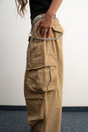 Khaki cotton baggy pants with high-waisted street fit, elastic back waistband, side and back pockets, zipper fly, and relaxed drape for everyday comfort by Sleeves Studios