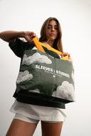 Cloud print laminated PP woven tote bag, 130gsm, with yellow-orange straps, Sleeves Studios logo and “Pack your style, baby!” slogan, lightweight and durable for daily use