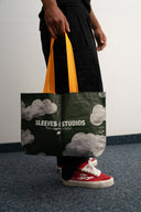 Cloud print laminated PP woven tote bag, 130gsm, with yellow-orange straps, Sleeves Studios logo and “Pack your style, baby!” slogan, lightweight and durable for daily use