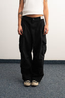 Khaki cotton baggy pants with high-waisted street fit, elastic back waistband, side and back pockets, zipper fly, and relaxed drape for everyday comfort by Sleeves Studios