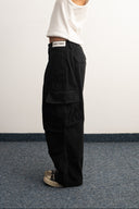 Khaki cotton baggy pants with high-waisted street fit, elastic back waistband, side and back pockets, zipper fly, and relaxed drape for everyday comfort by Sleeves Studios