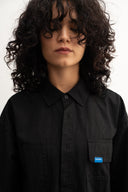 women wearing a black shirt with a blue label on a white background - sleeves studios - black Button-up shirt - blue label 