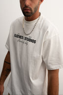 Man wearing a white t-shirt with dream big baby text on a plain background