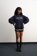 Washed navy oversized hoodie in premium heavyweight cotton, ultra-soft feel, with SLV logo and “Smile Baby” print on front, designed for comfort and vintage vibes by Sleeves Studios