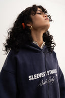 Washed navy oversized hoodie in premium heavyweight cotton, ultra-soft feel, with SLV logo and “Smile Baby” print on front, designed for comfort and vintage vibes by Sleeves Studios