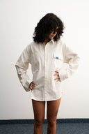 Person wearing a white shirt against a plain background  - sleeves studios - white Button-up shirt - blue label - white shirt