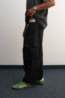 Khaki cotton baggy pants with high-waisted street fit, elastic back waistband, side and back pockets, zipper fly, and relaxed drape for everyday comfort by Sleeves Studios