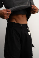 Khaki cotton baggy pants with high-waisted street fit, elastic back waistband, side and back pockets, zipper fly, and relaxed drape for everyday comfort by Sleeves Studios