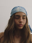 - blue bandanna / headscarf  with text "tie your style baby" Sleeves Studios' branding